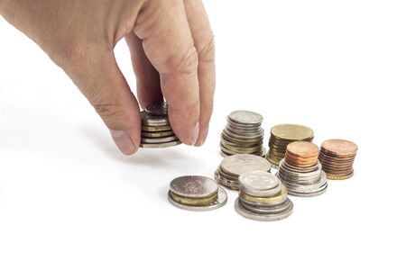 Hand holding and placing coins on the white background