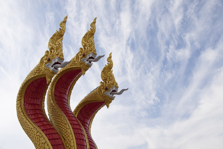 Goden three headed naga statue decorated the stairs leading to Buddha statueの写真素材