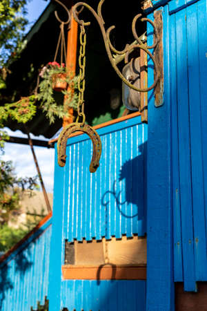 Steel horseshoe hanging on a chain near the house. High quality photoの素材 [FY310150280619]