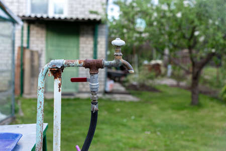 Old, rusty water tap in the country