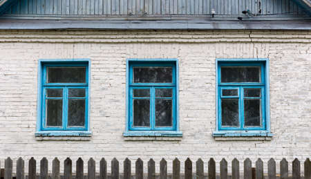 Three blue windows in a brick house