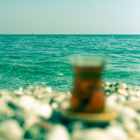 Tea in a glass out of focus on the background of the sea. Armudu.の写真素材