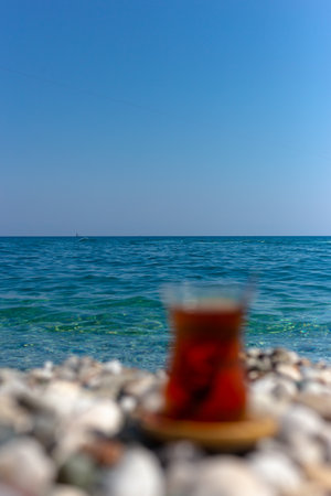 Tea in a glass out of focus on the background of the sea. Armudu.の写真素材