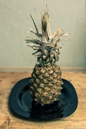 Pineapple on the kitchen table in a plateの写真素材