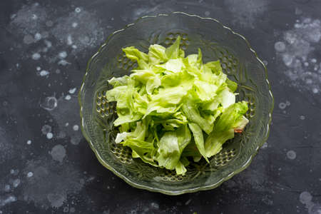 Salad in a glass bowl on a gray tableの写真素材