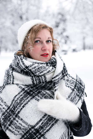 Winter portrait of a woman in a white hat and glovesの写真素材