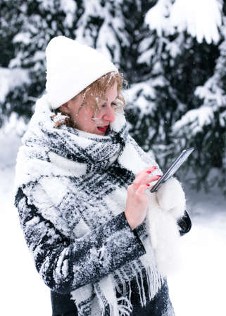 A young woman in winter uses a mobile phone.の写真素材