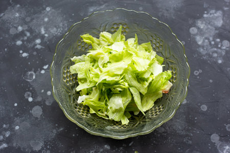 Salad in a glass bowl on a gray tableの写真素材