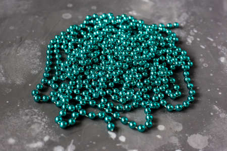 Long turquoise beads from lie on a gray surfaceの写真素材