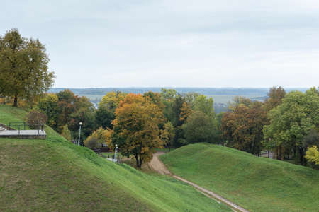 Green hills and yellowed autumn trees. Cloudy.の写真素材