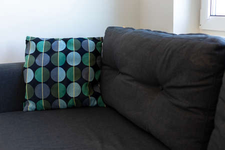 Dark blue sofa with blue and turquoise cushion in a white room
