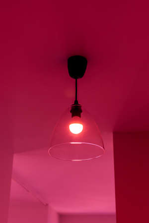 Luminary on the ceiling in the room in the red lightの写真素材