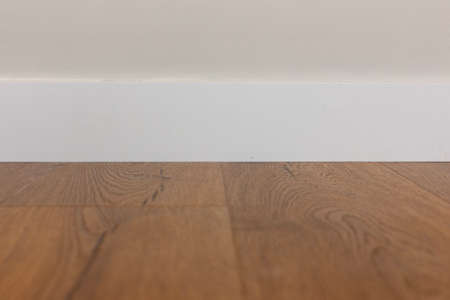 White baseboard, white wall and wood laminate.の写真素材