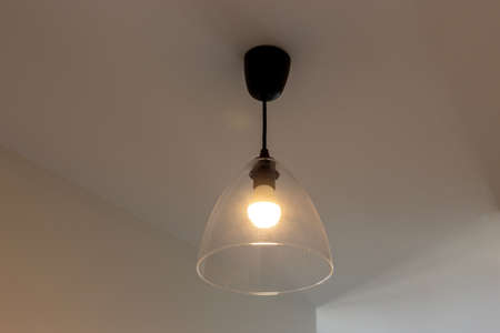 Lamp with glass shade on the ceiling in the roomの写真素材