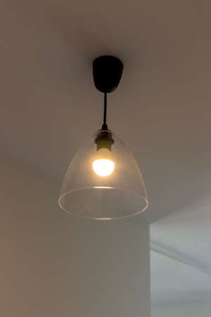 Lamp with glass shade on the ceiling in the roomの写真素材