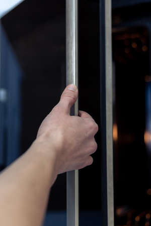 The hand opens the oven door. Kitchen equipment.の写真素材