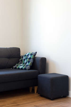Dark blue sofa with blue and turquoise cushion in a white roomの写真素材