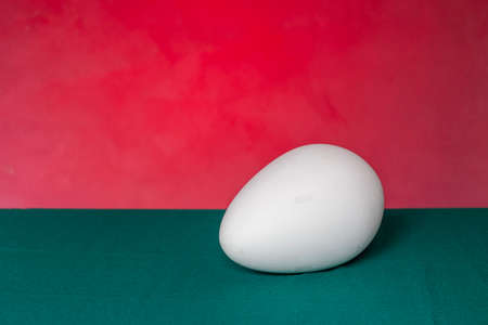 White egg on a red-green background. Easter egg.の写真素材