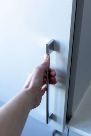 A hand opening a closet door.Wardrobe for things..の写真素材