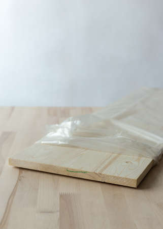 Furniture board in cellophane packaging on a wooden background. Wooden plank.の写真素材