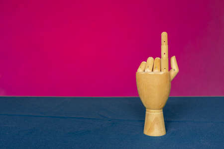 Wooden hand with index finger on a pink-blue backgroundの写真素材