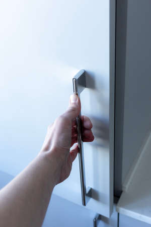 A hand opening a closet door.Wardrobe for things..の写真素材