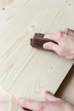 Sanding boards by hand. Sanding with abrasive paper.の写真素材