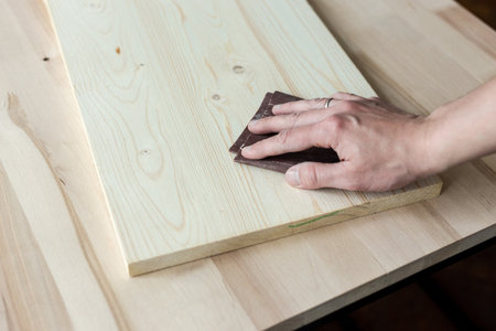 Sanding boards by hand. Sanding with abrasive paper.の写真素材