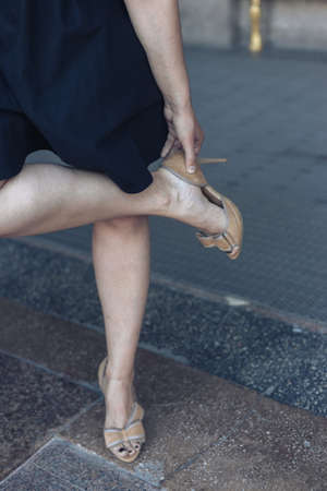 Woman putting on high heel shoes. Beautiful shoes.の写真素材