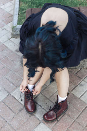 Woman tying shoelaces on leather rough bootsの写真素材