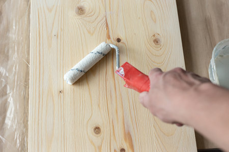 Coating the board with varnish using a rollerの写真素材