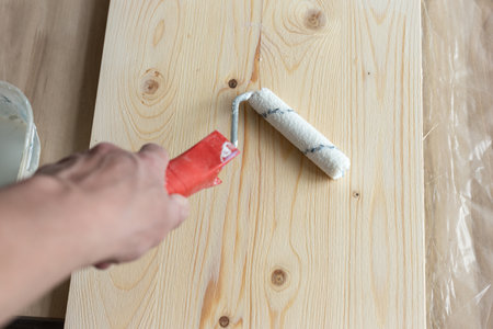 Coating the board with varnish using a rollerの写真素材