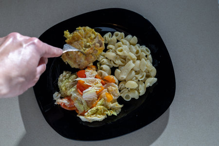 Pasta, salad and cucumber on a plate.の写真素材