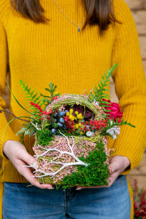 flower composition in hands of florist at the stage of completion