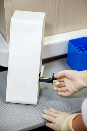 The specialist of the laboratory places the samples in a special apparatus for studying the...