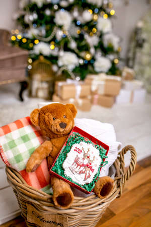 Cookie with deers and numbers 2019 in carton box on a teddy bear in a wicker basket in front of...
