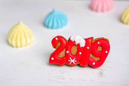 Gingerbread in the form of a numbers 2019 and meringue on a white vintage background. Holiday...