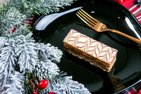 Delicious puff cake covered with glazed. Tasty dessert food in close up. Desserts served on black plate, decorated fir branches. French cuisine. Christmas theme.の写真素材