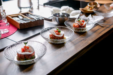 The layout of the finished dish. Tuna tartar on a plate. Master class in the kitchen. The process of...