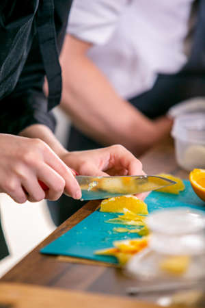 Cook cuts an orange. Master class in the kitchen. The process of cooking. Step by step. Tutorial....