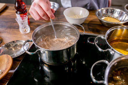 Cook stir the noodles in the pan. Master class in the kitchen. The process of cooking. Step by step....