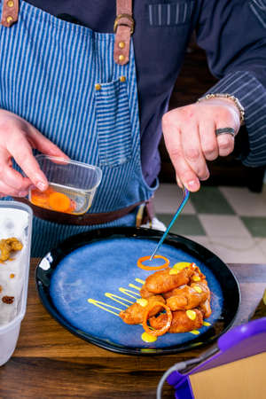 Chef decorates the dish from smoked catfish head in batter. Master class in the kitchen. The process of cooking. Step by step. Tutorial. Close-up.の写真素材