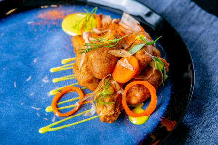Smoked catfish head in batter. European cuisine. The work of a professional chef. Dish from a...