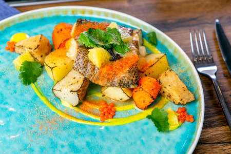 Far Eastern deep-sea perch, stewed in coconut milk and root vegetables confit. European cuisine. The...