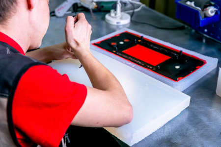 A worker extract the plastic detail from the mold. Manufacturing of plastic products. Medium...