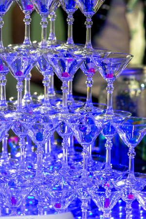 A pyramid of empty martinas in the restaurant. Table setting for celebration. Banquet service, catering food.の写真素材
