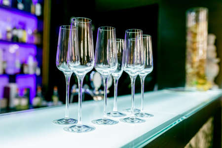 Empty wine glasses on the bar table in the restaurant. Table setting for celebration. Banquet service, catering food.の写真素材