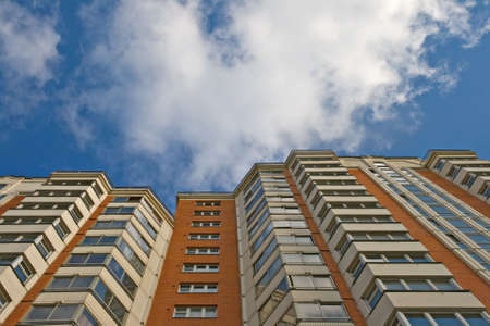 A residential multistory house and sky with clouds, view from belowの写真素材