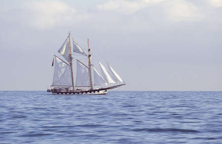 Ship with white sails in the calm seaの写真素材