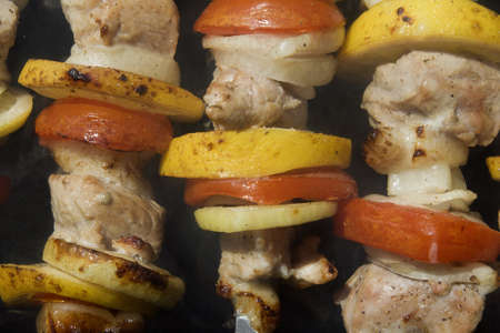 Raw shashlik with lemon and tomatoes on a skewerの写真素材